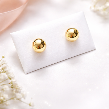 Boucles d’oreilles boule en or massif 18 carats 750 en or jaune poli, présentées sur support blanc.