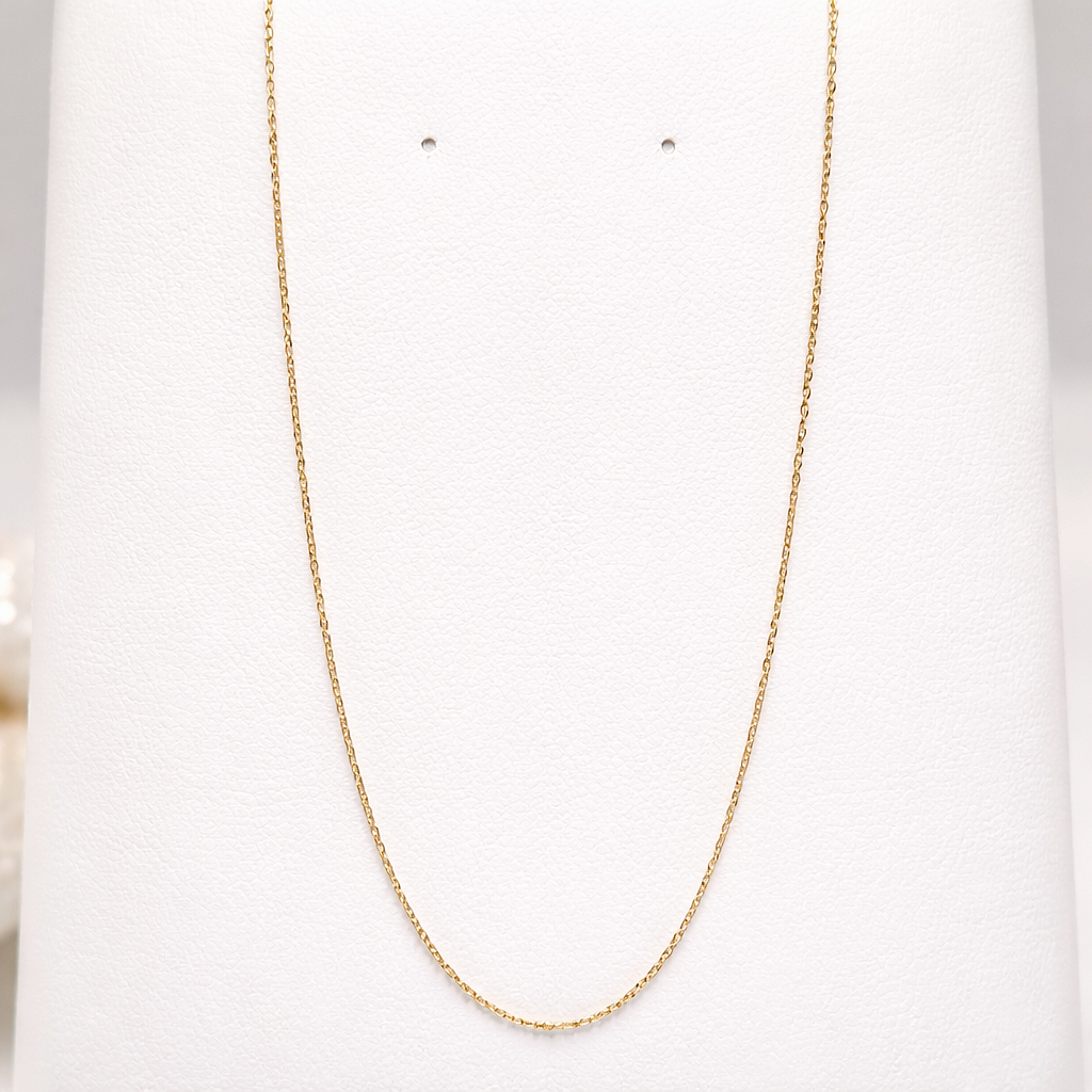 Chaîne fine maille forçat en or massif 18 carats 750 présentée seule, finition or jaune poli.