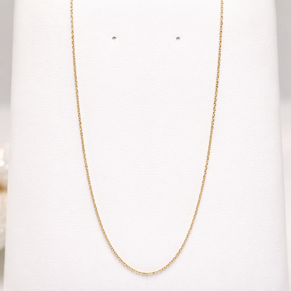 Chaîne fine maille forçat en or massif 18 carats 750 présentée seule, finition or jaune poli.