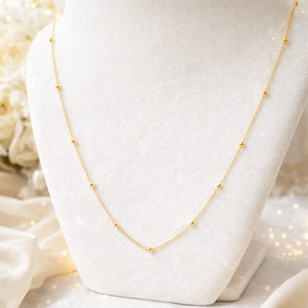 Collier maille boules en or massif 18 carats porté, chaîne fine avec boules réparties régulièrement.