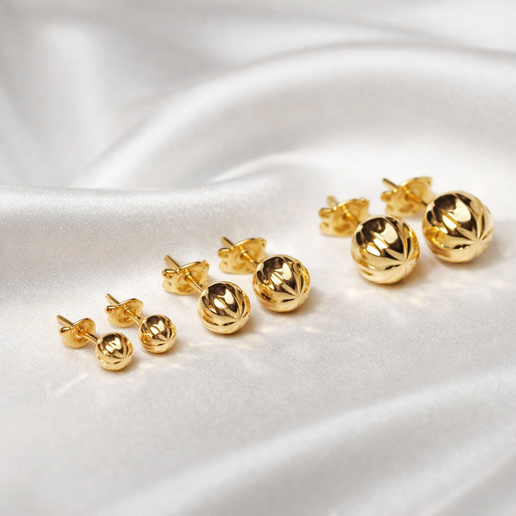 Puces d’oreilles boules ciselées en or massif 18 carats 750 présentées en plusieurs tailles.