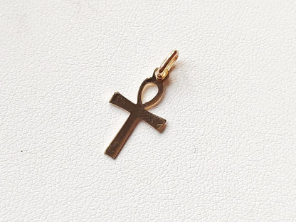 Pendentif croix égyptienne Ankh en or massif 18 carats 750 posé à plat, montrant la forme et les reliefs.