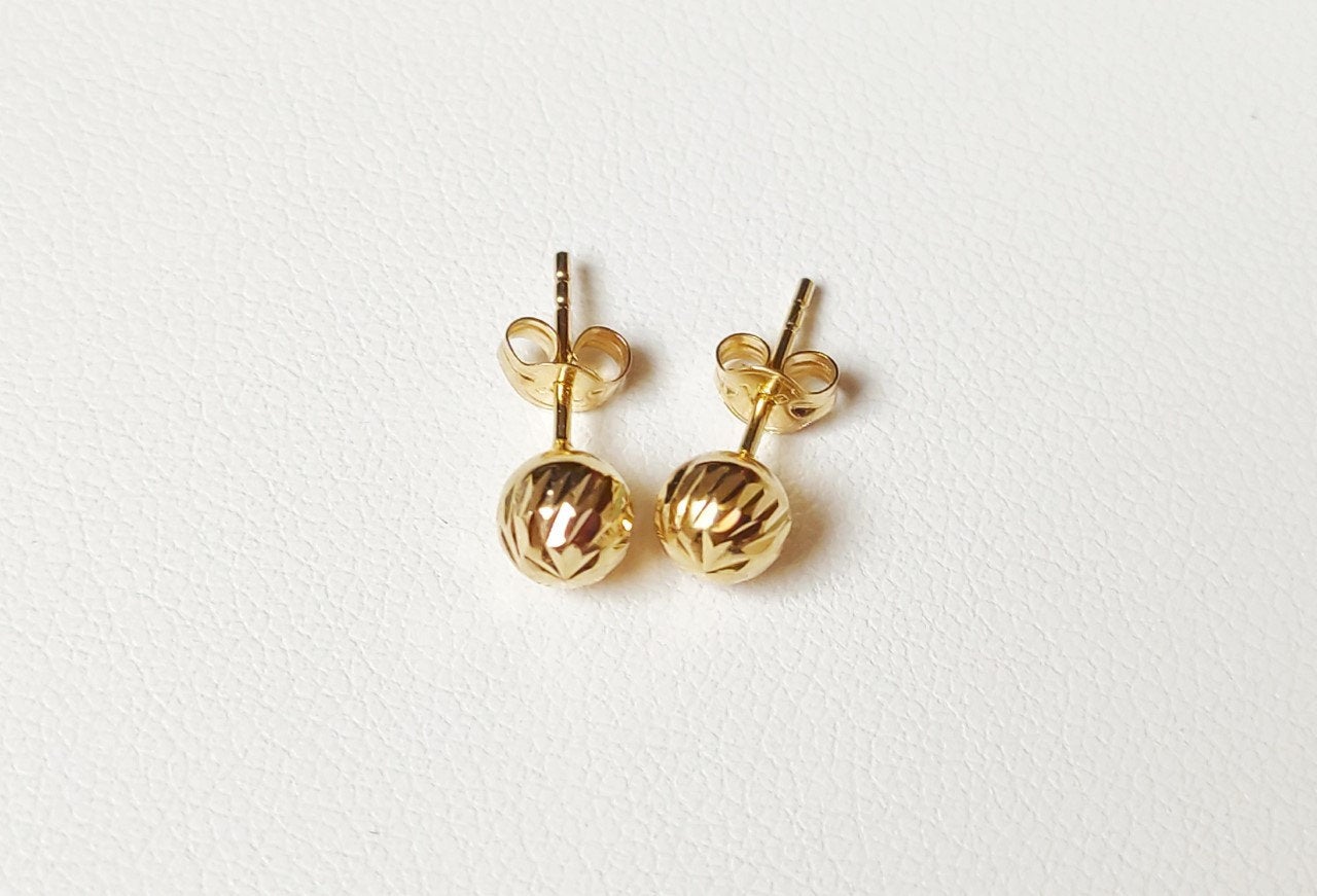 Vue arrière de puces d’oreilles boules facettées en or massif 18 carats 750 avec tiges de fixation.