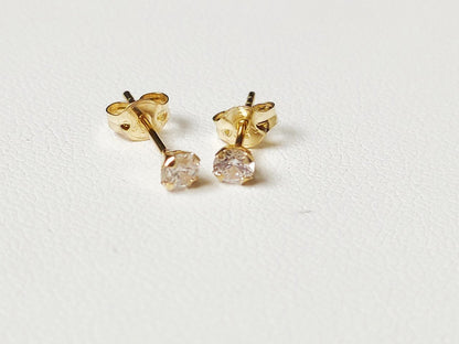 Paire de puces d’oreilles en or massif 18 carats 750 avec pierre ronde transparente vue de face.