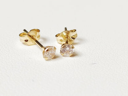 Puces d’oreilles en or massif 18 carats 750 montrant le serti griffes et la tige de fixation.